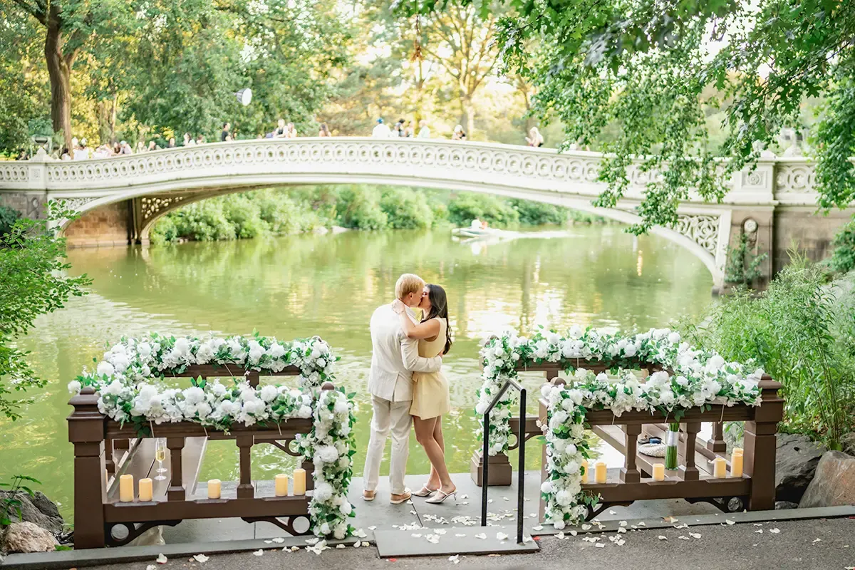 Romantic Bow Bridge proposal in Central Park with white flower decorations